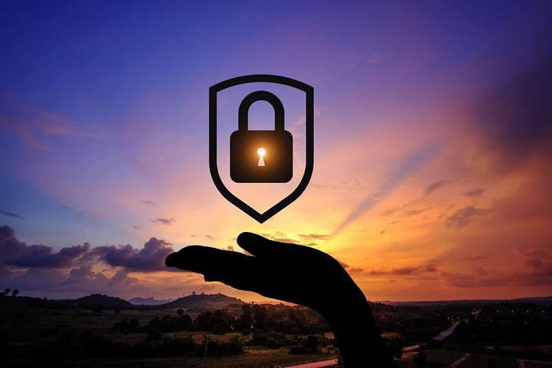 hand with a digital lock above it during sunset