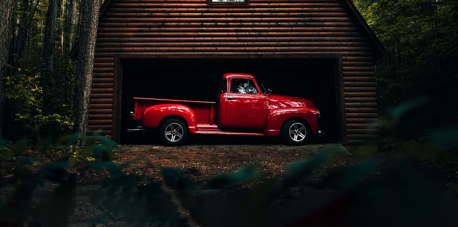 red 60's model pickup in a barn
