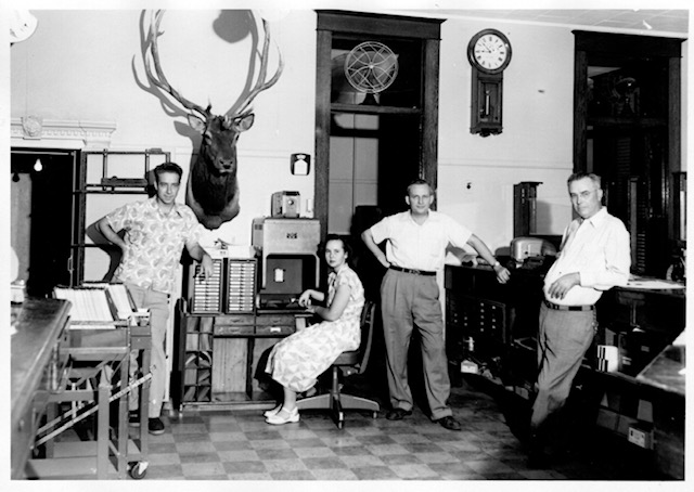 Group of people posing in a bank during the 1930s