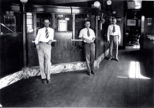 3 men standing in front of a banking cage during the 1950s